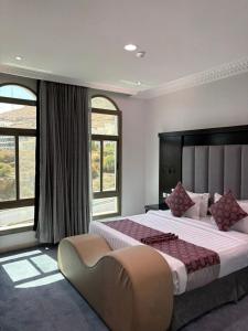 a large bedroom with a large bed and windows at فربيون للشقق الفندقية ابها-ferbion hotel apartment in Abha