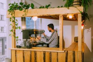 un hombre está preparando comida en una cocina en Hessenland Hotel Kassel Innenstadt by Stay Awesome, en Kassel