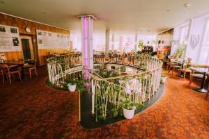 a room with a bunch of plants and tables and chairs at Kulturhotel Hessenland Kassel Innenstadt by stay awesome in Kassel
