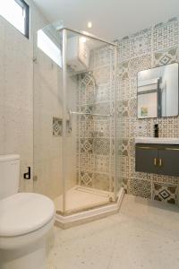 a bathroom with a shower and a toilet in it at Palm Stay Residence in Nagoya