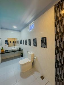 un baño con inodoro y lavabo en Ari Stay Thoddoo, en Thoddoo