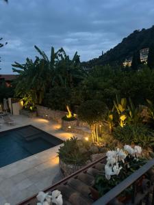 a backyard with a pool and landscaping at night at Villa Ragona Taormina in Taormina