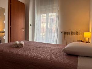 a bedroom with a bed with two slippers on it at B&B Altea in Pescara