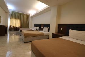 ブリンチャンにあるIris House Hotel Cameron Highlandsのベッド2台とソファがあるホテルの部屋 +49枚の写真