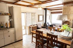a kitchen and dining room with a table and chairs at Ou Klipskuur Self-Catering Accommodation in Fraserburg