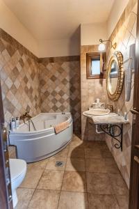 a bathroom with a tub and a sink and a toilet at Guesthouse Iris in Tsagarada +203 photos
