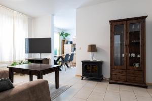 a living room with a couch a table and a stove at Ferienwohnungen Meerzeit in Burhave
