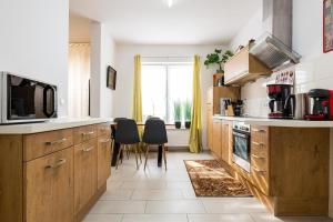 a kitchen with wooden cabinets and black chairs and a window at Ferienwohnungen Meerzeit in Burhave