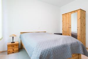 a bedroom with a bed and a wooden cabinet at Ferienwohnungen Meerzeit in Burhave +2 photos