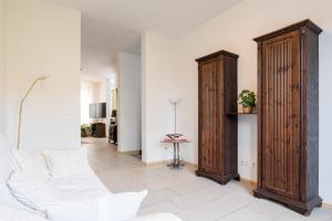 a living room with a white couch and wooden cabinets at Ferienwohnungen Meerzeit in Burhave