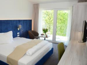 ein Hotelzimmer mit einem Bett und einem großen Fenster in der Unterkunft DORMERO SeHo Graz in Graz
