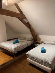 deux lits jumeaux dans une chambre mansardée avec poutres en bois dans l'établissement "Rêves de Gamins", Chambre de droite, 4 couchages dans gîte de campagne "La Camusière", proche du Pôle Européen et du circuit des 24h, à Champagné