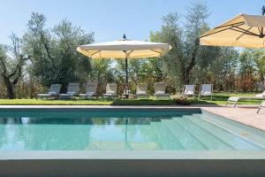 a swimming pool with chairs and an umbrella at Villa Mami - Boutique Suites Adults Only in Siena