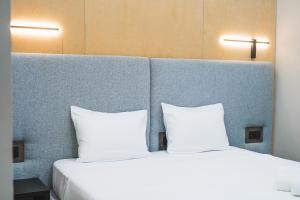 two beds with white pillows sitting next to each other at Pura Vida Boutique Hotel Tbilisi in Tbilisi City