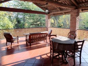 a screened porch with a table and chairs and a table and benches at Agriturismo Cascina Frati in Canelli