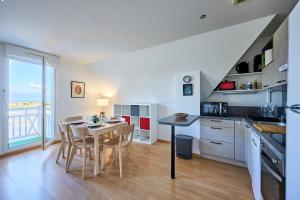 a kitchen and dining room with a table and chairs at Le Quai Bleu - 200 m de la plage in Courseulles-sur-Mer