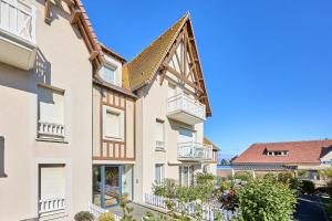 a building with balconies on the side of it at Le Quai Bleu - 200 m de la plage in Courseulles-sur-Mer +7 photos
