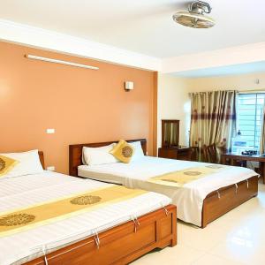 a bedroom with two beds and a desk at Love Hotel in Hanoi