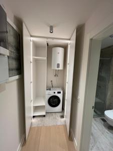 a laundry room with a washer and dryer in it at Zep Promenade Spa Apartment in Vrnjačka Banja +9 photos