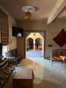 a living room with couches and chairs and a table at Auberge La Source in Merzouga