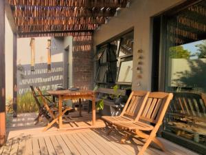 a patio with chairs and a table on a deck at Point Garden Cottage in Elands Bay +4 photos