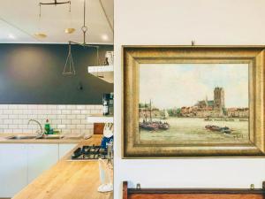 a painting hanging on a wall in a kitchen at Point Garden Cottage in Elands Bay
