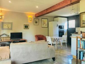 a living room with a couch and a table at Point Garden Cottage in Elands Bay