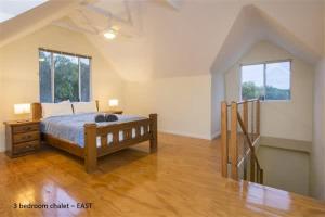 a bedroom with a bed and a wooden floor at Sea Breeze East Chalet Yallingup in Yallingup