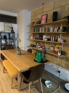 a dining room with a wooden table and bookshelves at Appartement avec cour in Bordeaux +1 photo