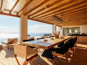 a wooden dining table and chairs on a deck at Villa Montessito Mykonos in Tourlos