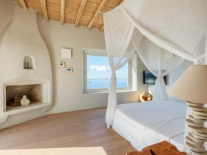 a bedroom with a bed and a window at Villa Montessito Mykonos in Tourlos +69 photos