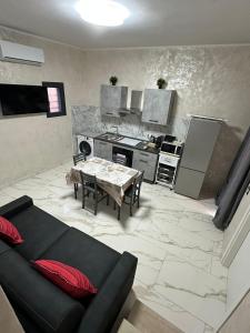 a living room with a table and a kitchen at Testa House 2 0 in Catania
