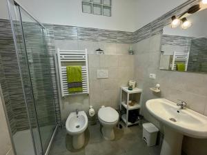 a bathroom with a toilet and a sink and a shower at Relax Apartment in Civitavecchia