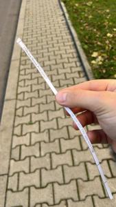 una mano sosteniendo una cuerda blanca sobre una acera de ladrillos en The Country Stop Apartment, en Łęki