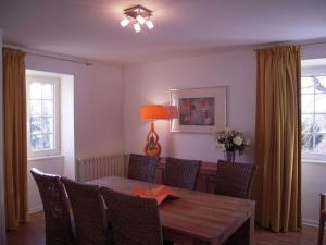 une salle à manger avec une table et des chaises en bois dans l'établissement Gîte de Ségonac, à Saint-Georges-de-Luzençon