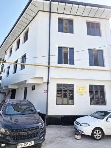 two cars parked in a parking lot in front of a building at New Apartment in Tashkent in Tashkent