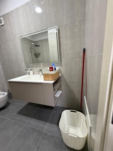 a bathroom with a sink and a mirror and a toilet at Modern 2BR Near City Ring & Main Road Access in Tirana +8 photos