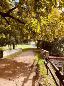 a dirt road in a park with trees and a fence at Grande maison de ville MALO LEONE 250m2 pour 15 personnes proche du Puy du Fou in Mauléon