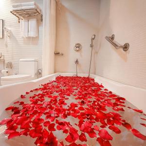 a bath tub filled with red rose petals at Nature Valley Cottage, Mussoorie in Mussoorie