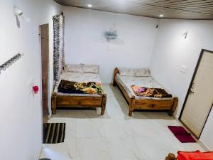 a room with two beds and a mirror on the wall at Doddagadde Stays in Sakleshpur