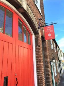a red door on a brick building with a sign on it at Arthouse Canterbury-Free Secure Parking in Canterbury