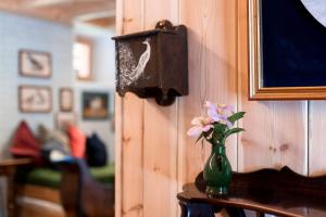 a vase with flowers on a table next to a wall at Wohnung ASSUNTA in Soprabolzano +24 photos