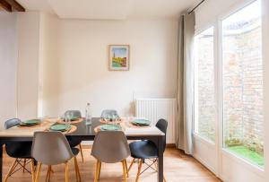 a dining room with a table and chairs and a window at LE 219 - Maison tout confort à Amiens Wi-Fi rapide, Netflix, calme & proche centre in Amiens