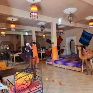 a room with a bedroom with a bed and a camel at Auberge La Source in Merzouga +68 photos