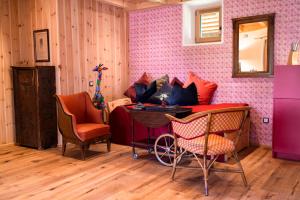 a room with a pink wall with chairs and a table at Wohnung FRIEDRICH in Soprabolzano