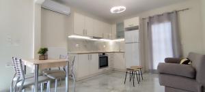 Δίκταμο في موزاكيون: مطبخ وغرفة معيشة مع طاولة وأريكة