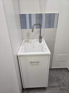 a white sink with a faucet in a bathroom at Casetta Di Nonno Paolo in Contrada Mastrissa