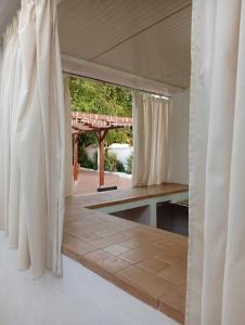 ein Zimmer mit weißen Vorhängen und einer Terrasse in der Unterkunft Alojamiento Rural Paraiso Pozuela in Jaén + 38 Fotos