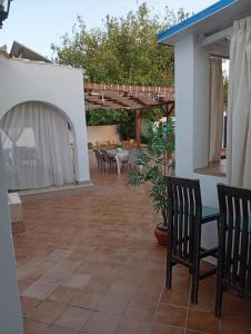 eine Terrasse mit Stühlen und Tischen und einer Pergola in der Unterkunft Alojamiento Rural Paraiso Pozuela in Jaén
