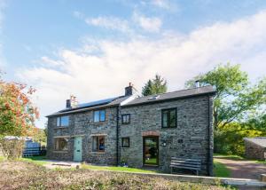 an old stone house with a slate roof at Abereithrin Cottage in Pentre-bâch
